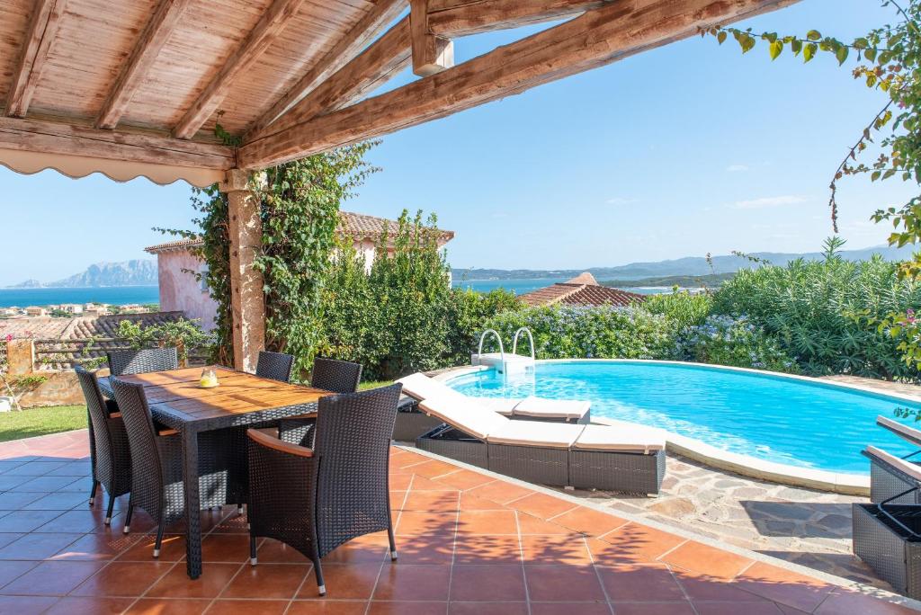a patio with a table and chairs and a swimming pool at Villetta Nicola in Olbia