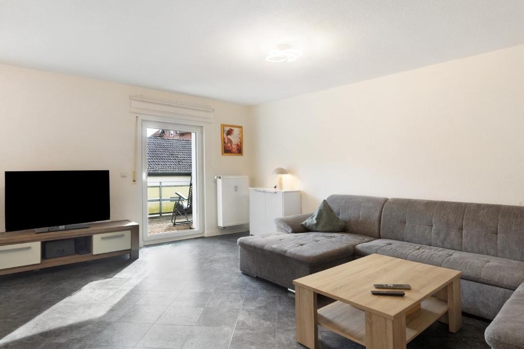 a living room with a couch and a flat screen tv at Fewo Schneider Bad Wildungen in Bad Wildungen