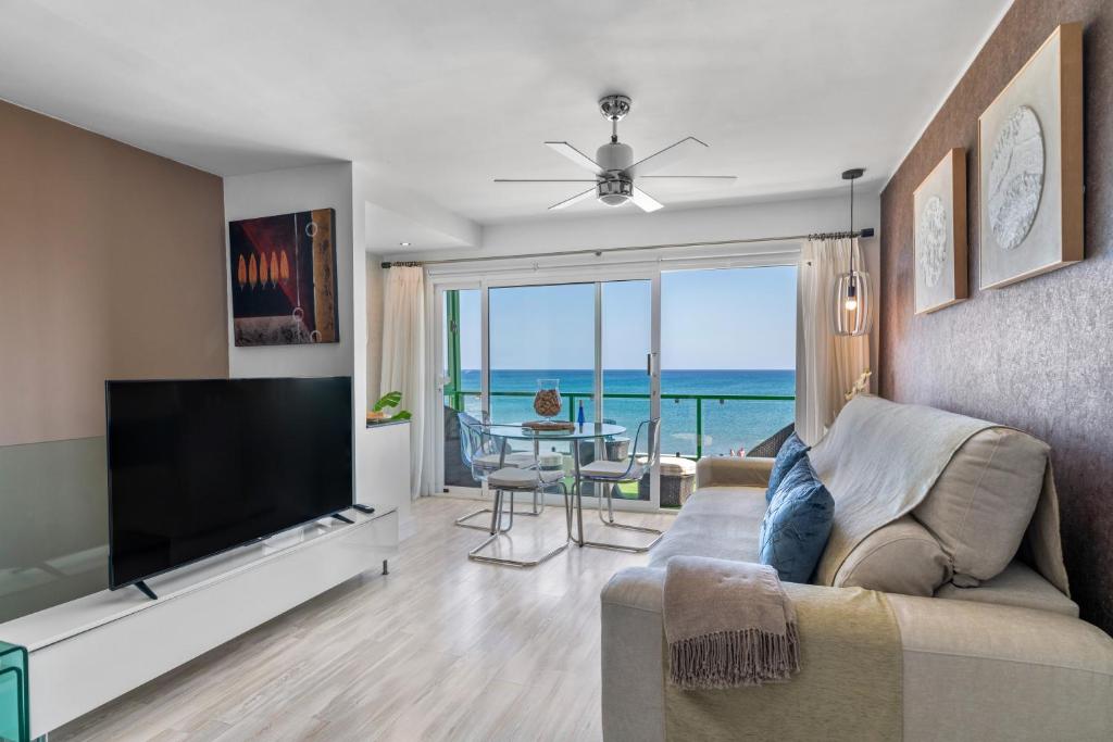 a living room with a couch and a flat screen tv at 51 Avenue Playa Honda in Playa Honda