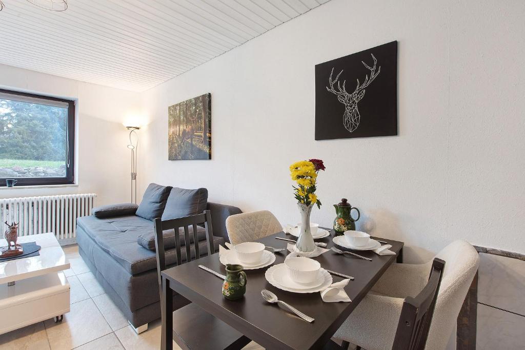 a living room with a table and a couch at Schwarzwaldglück in St. Blasien