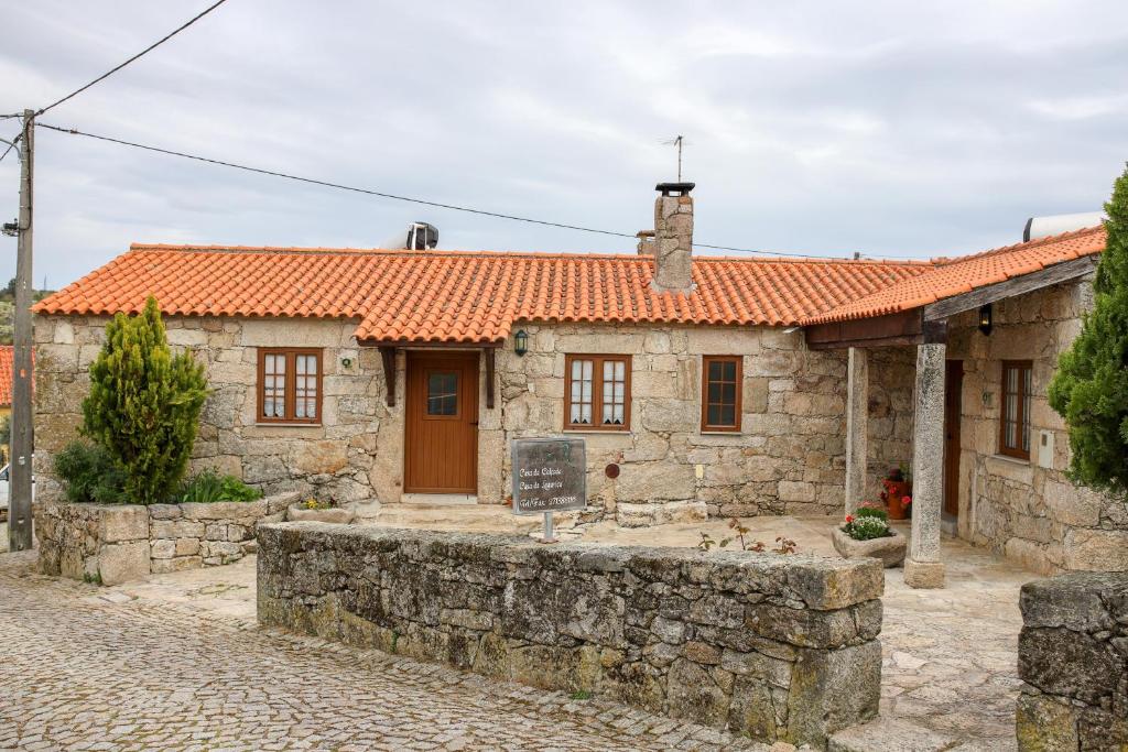 a stone house with an orange roof at Casa Da Calçada - Turismo Sortelha in Sortelha