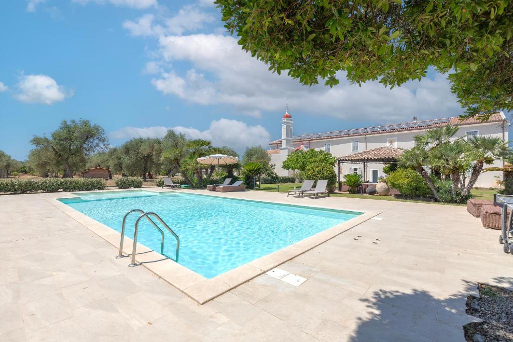 a swimming pool in a courtyard with a building at Dimora Sella - Casa Monica in Alghero