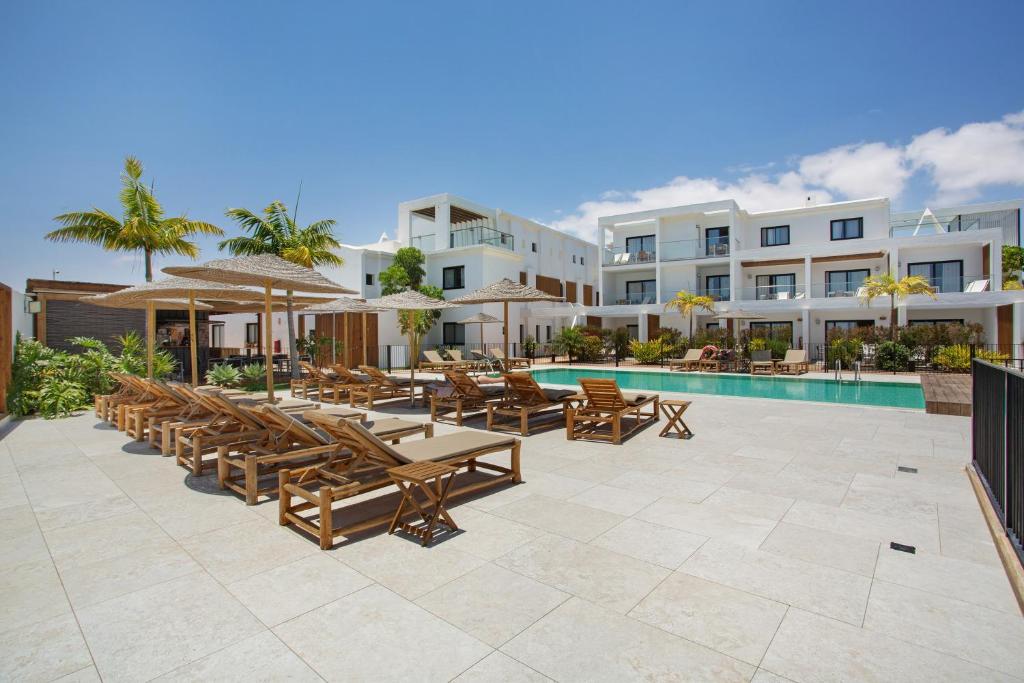 an outdoor patio with tables and chairs and a pool at Casa Sunrise in Parque Holandes