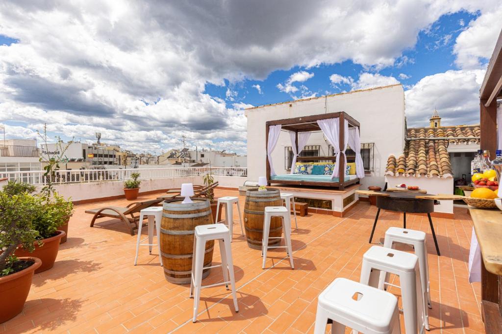 a rooftop patio with tables and stools on a roof at La Casa de Manuel in Estepona