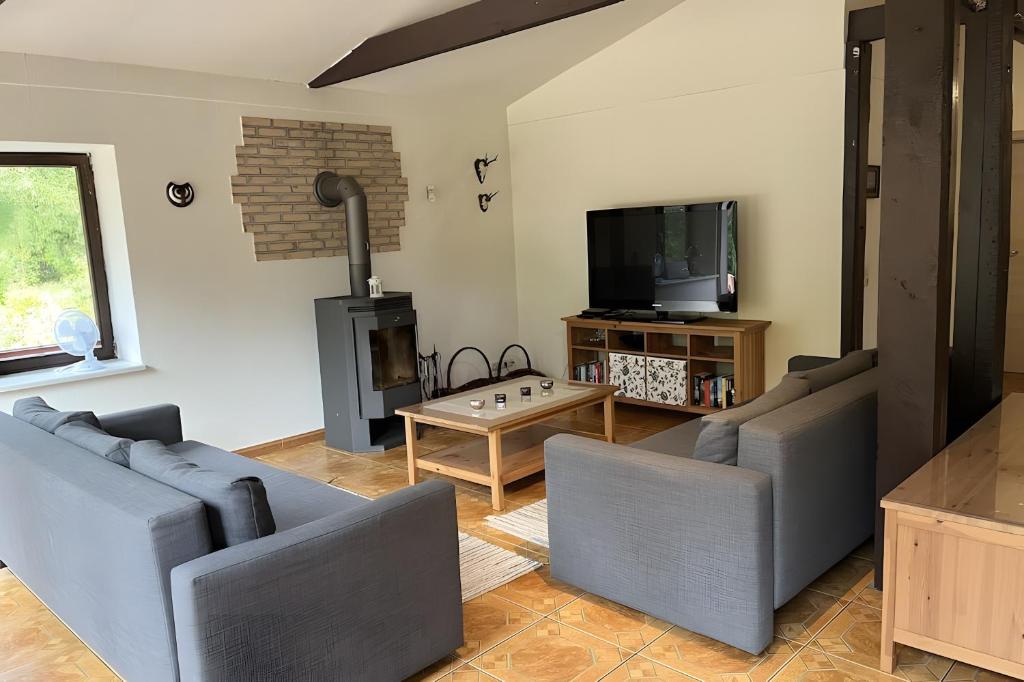 a living room with two couches and a tv at Ferienhaus Vossberg in Grabow