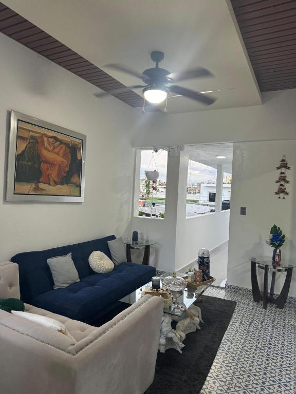 a living room with a couch and a ceiling fan at HOTEl LIRIOS DEL MAR in Santo Domingo
