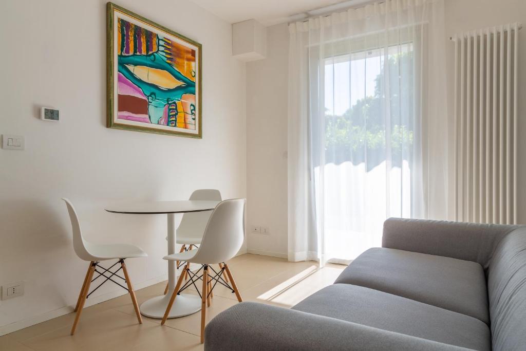 a living room with a couch and a table and a window at Baseventuno 3 bilocale piano terra in Sirmione