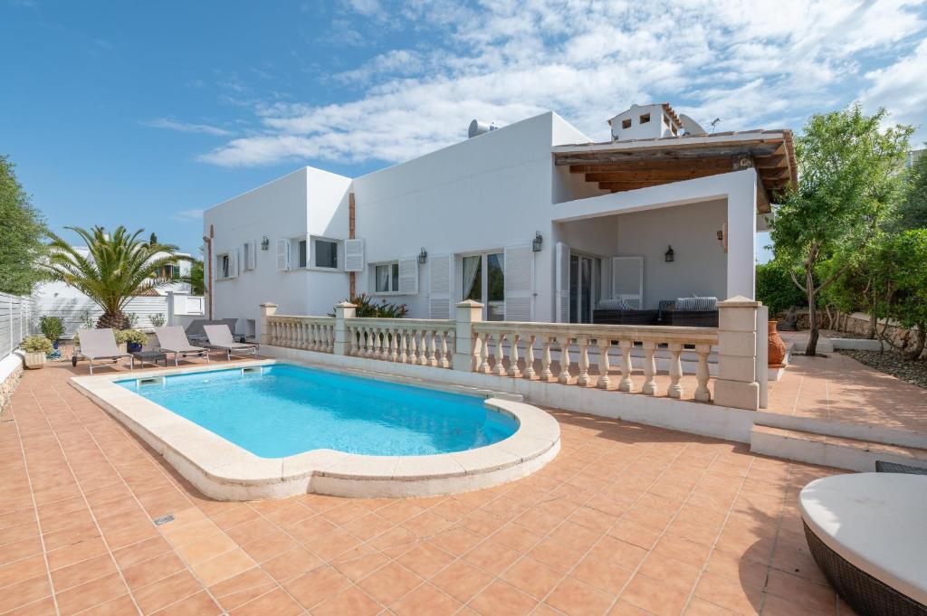 a villa with a swimming pool in front of a house at Villa Luca in Cala d´Or
