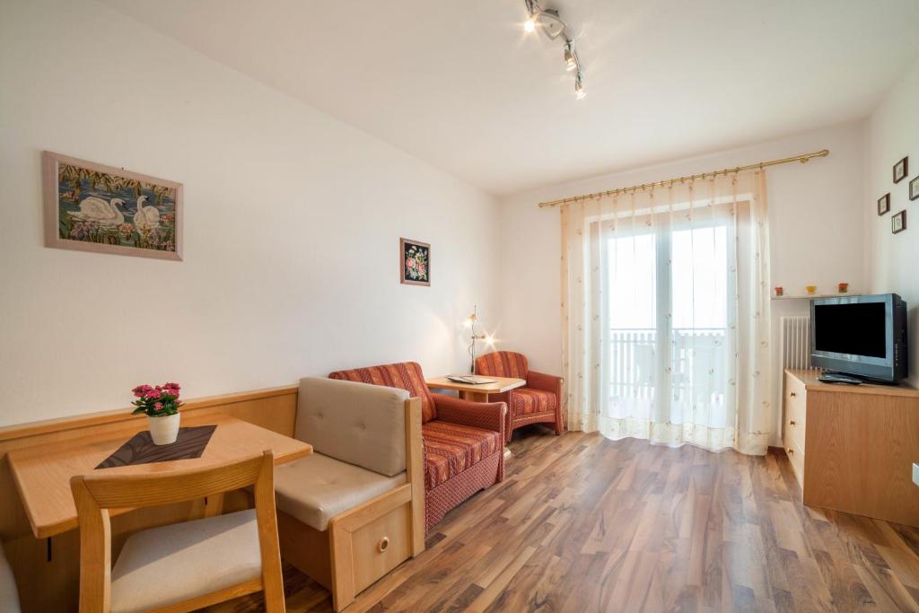 a living room with a couch and a table at Haus Hohenrain Ferienwohnung 3 in Schenna