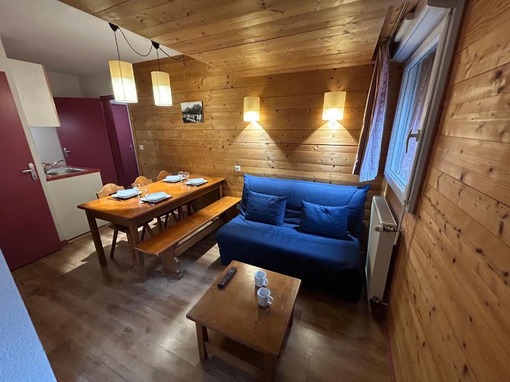 a living room with a blue couch and a table at L'Izard Piscine, Jacuzzi, Parking in Cauterets