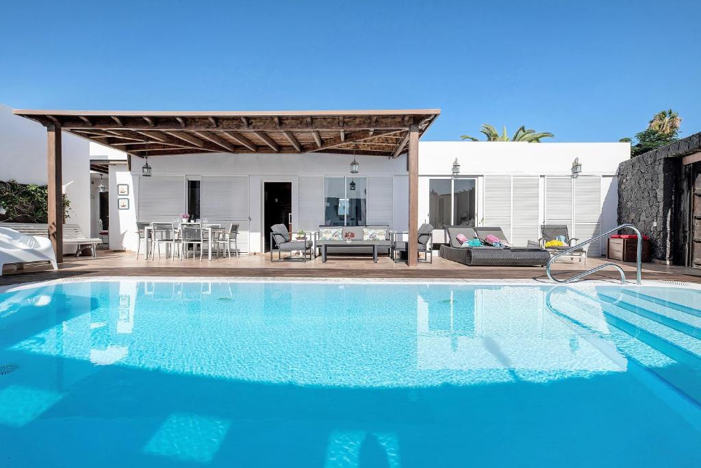 a swimming pool in front of a house at Villa Fae in Playa Blanca