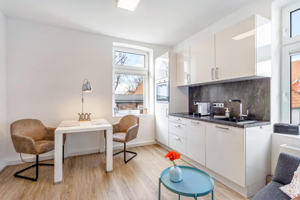 a kitchen and living room with a table and chairs at Ferienwohnung am Wall in Soest