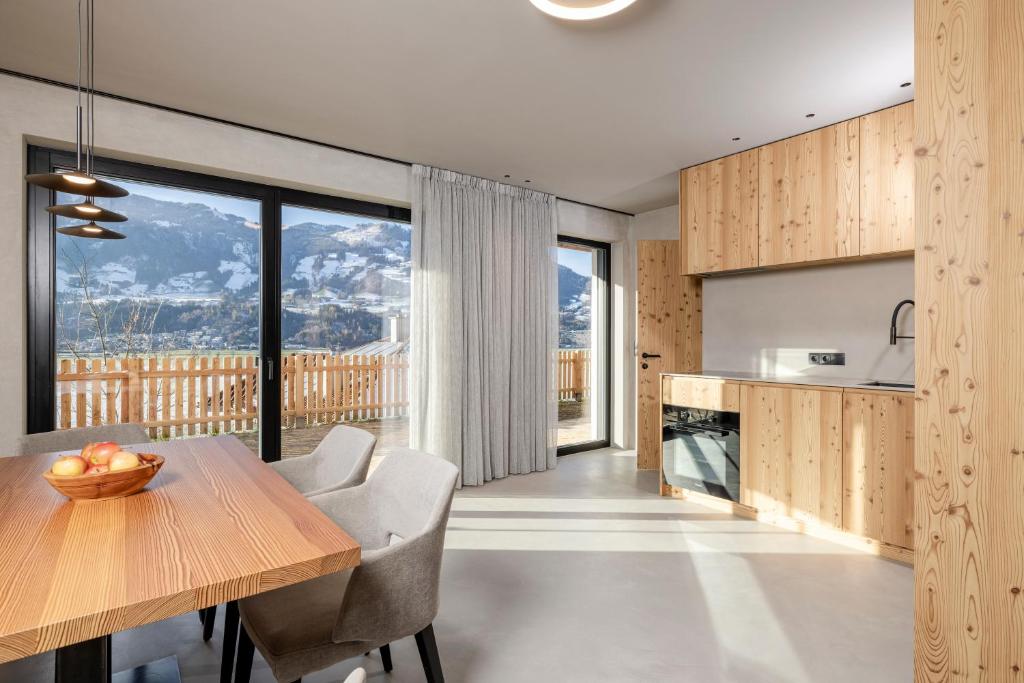 a kitchen with a wooden table and a large window at Vronis Lodge in Hart im Zillertal