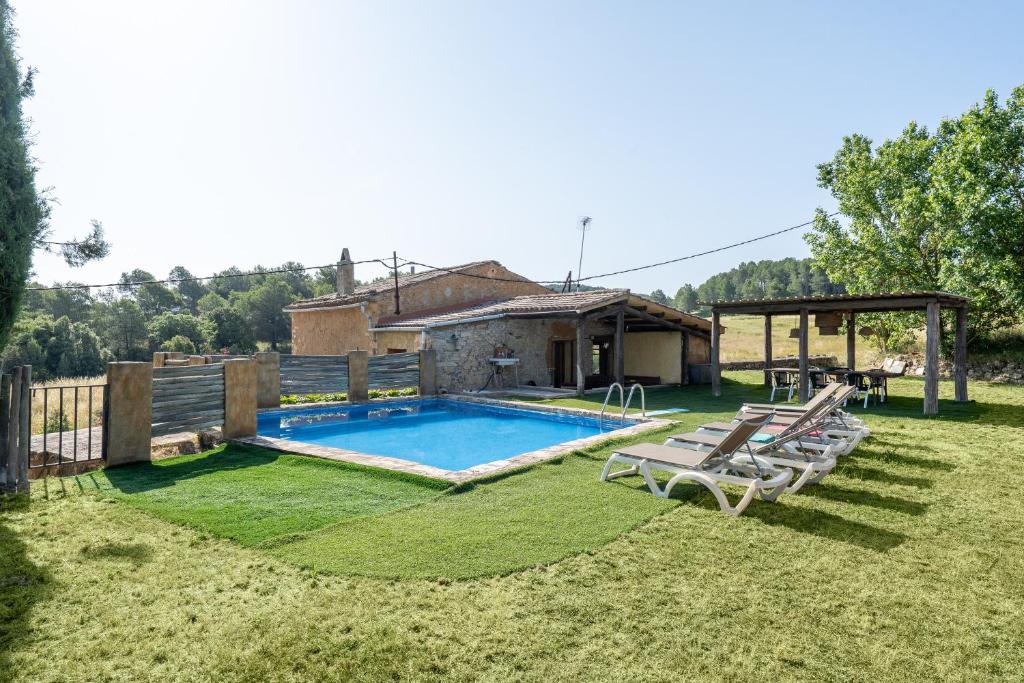 a backyard with a swimming pool and a house at Masia Caltiku in Els Ranxos de Bonany