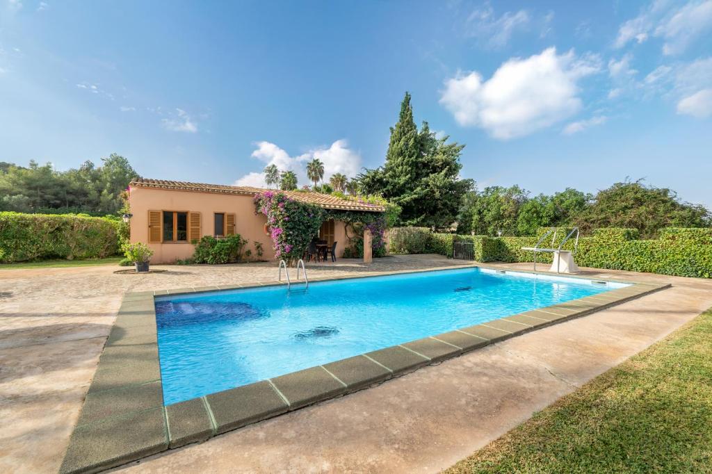 a swimming pool in a yard with a house at Can Jaume Des Carritxó in Felanitx