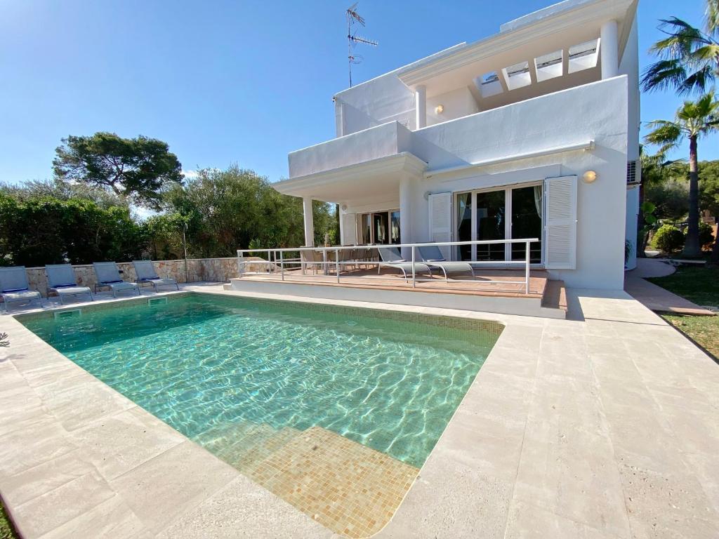 a villa with a swimming pool in front of a house at Villa Es Ratolí in Cacla D'or