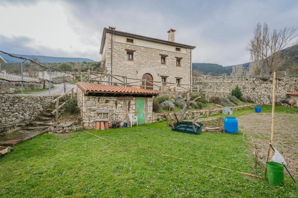 a stone house with a yard in front of it at Torres 1 in Quintana de Valdivielso