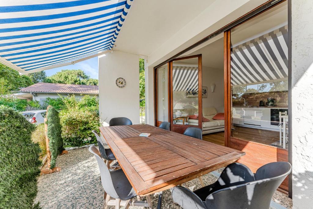 a dining room with a wooden table and chairs at Appartement Rose Mousse - Abatilles in Arcachon