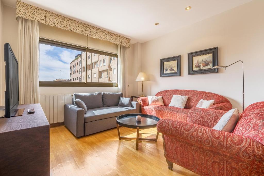 a living room with two couches and a tv at Central, Spacious Parking in Granada