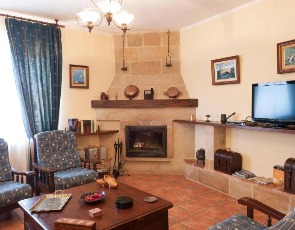 a living room with a fireplace and a tv at Casa Rural Vielba in Barruelo de Santullán