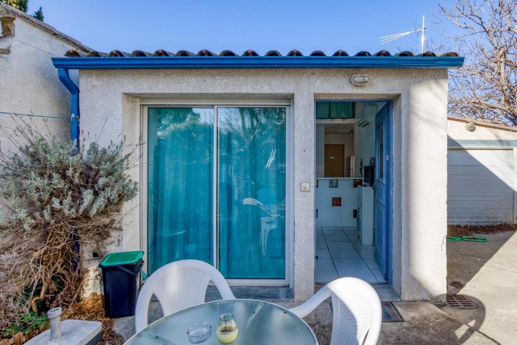 a patio with a table and chairs in front of a door at Maisonnette Lattes in Lattes
