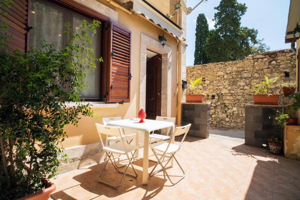 a white table and chairs on a patio at Casa Carly Taormina in Taormina