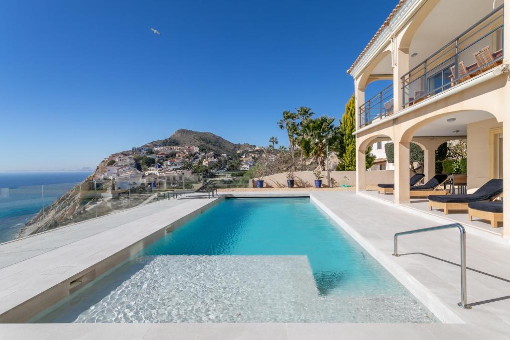 a swimming pool in a house with a view of the ocean at Villa Mina - First Line Villa in El Campello