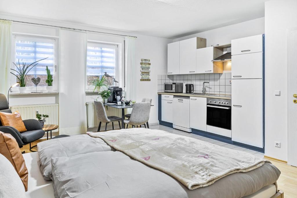 a white kitchen with a large bed in a room at Angie's Ferienapartment Thermalbad in Bad Staffelstein