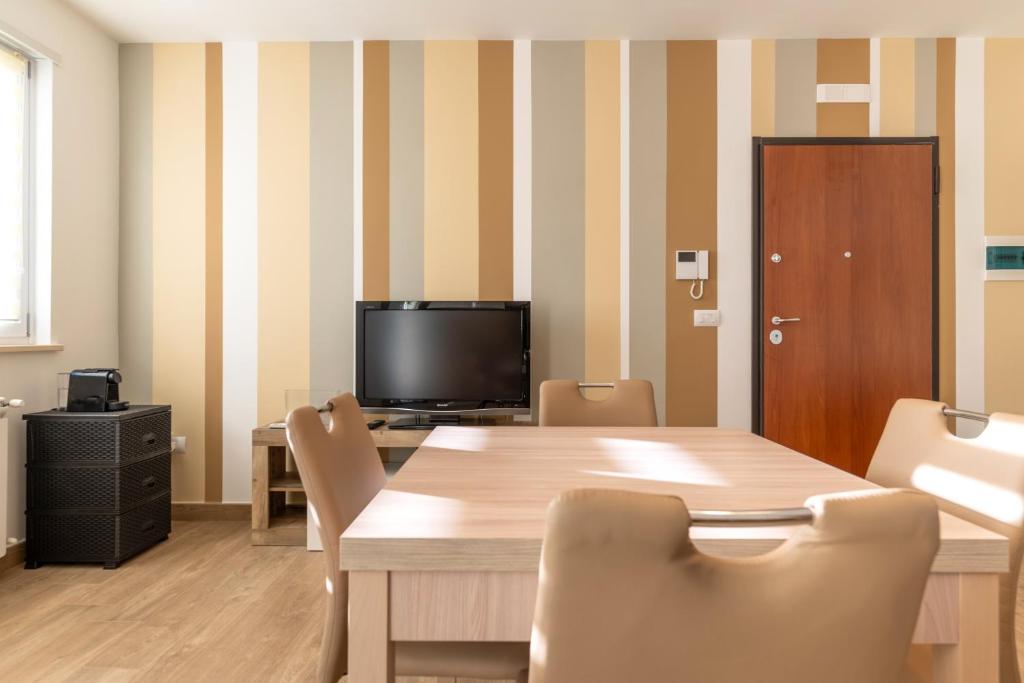 a dining room with a table and a television at Casadamare Salento in Brindisi