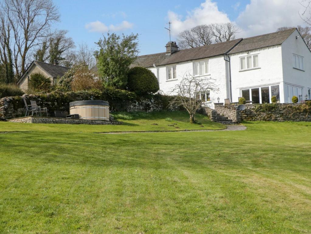 a white house with a large yard at Barn Howe in Kendal