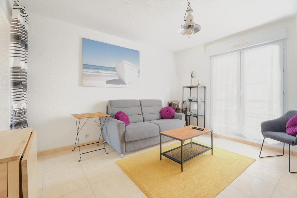 a living room with a couch and a table at Le Saint Martin Duplexe à la Mer in Bréhal