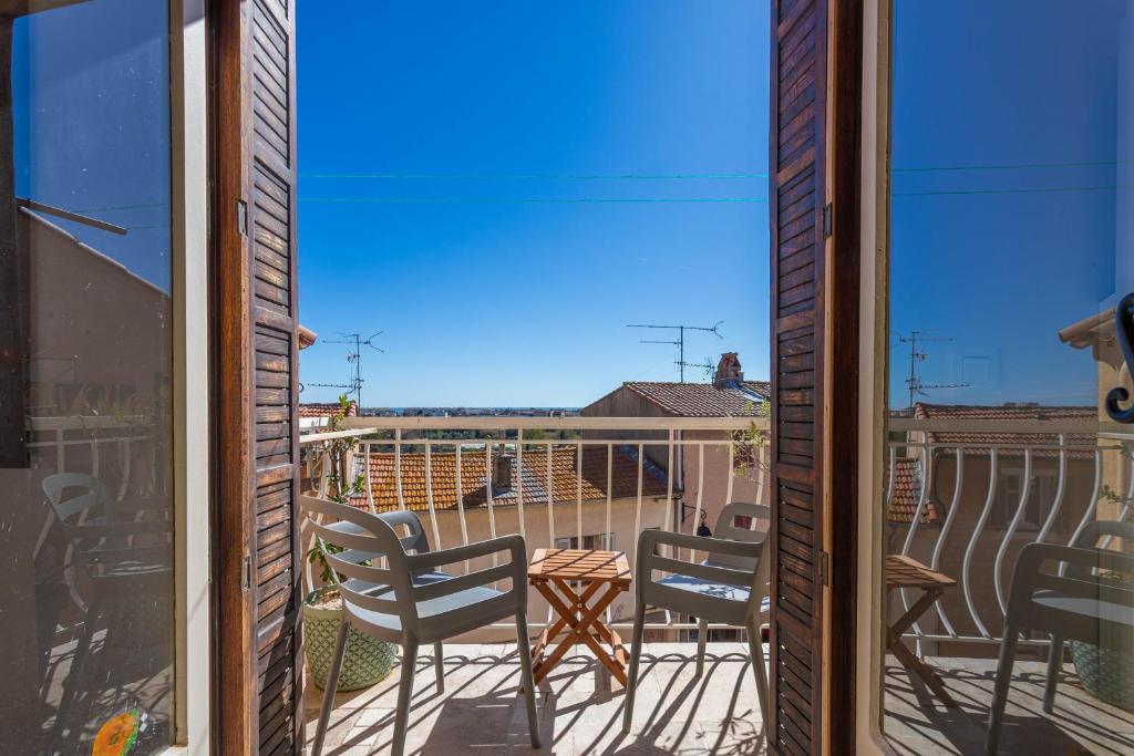 a view of a balcony with chairs and a table at Maison de ville Fréjus in Fréjus