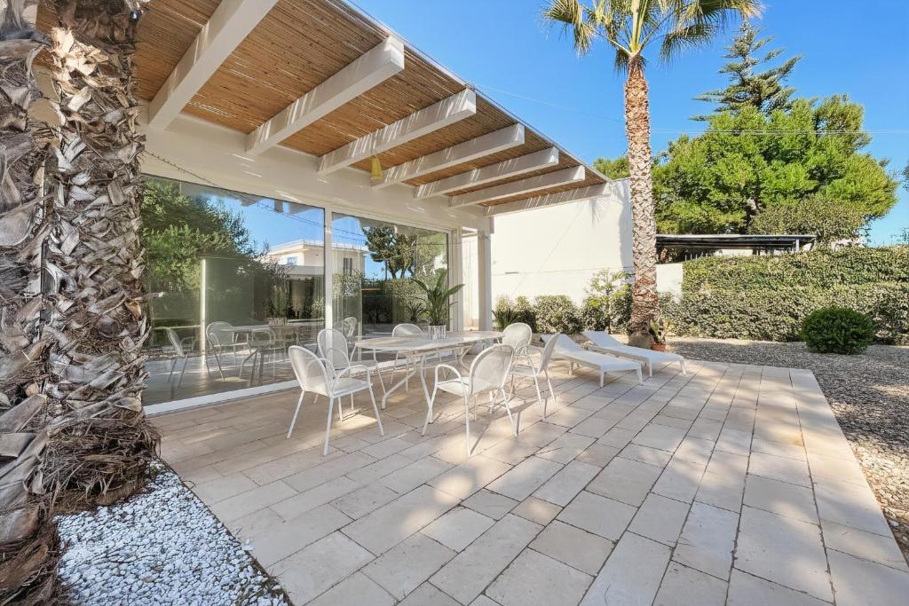 a patio with a table and chairs and a palm tree at Villa Traimari in Trani