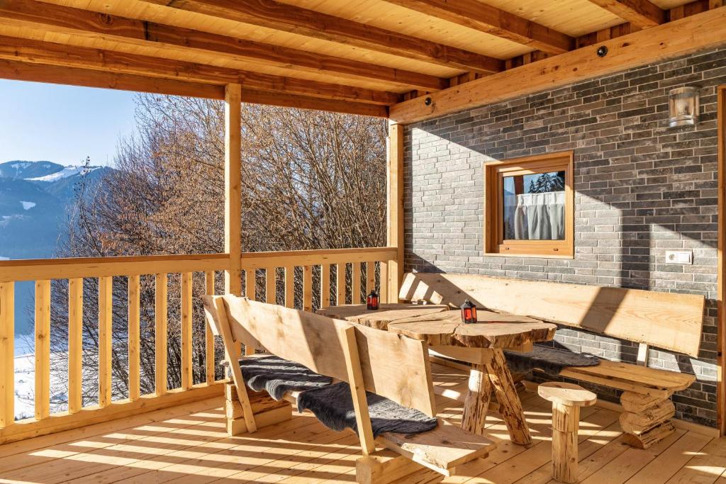 a wooden porch with a table and chairs on a deck at Haus Glückswiese in Großhartberg