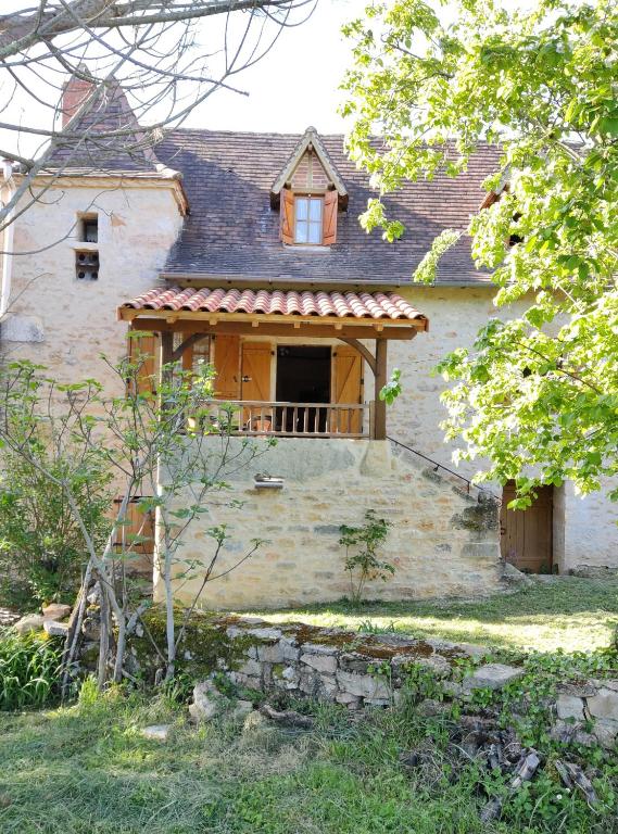 an old house with a window and a balcony at Maison Quercynoise in Corn