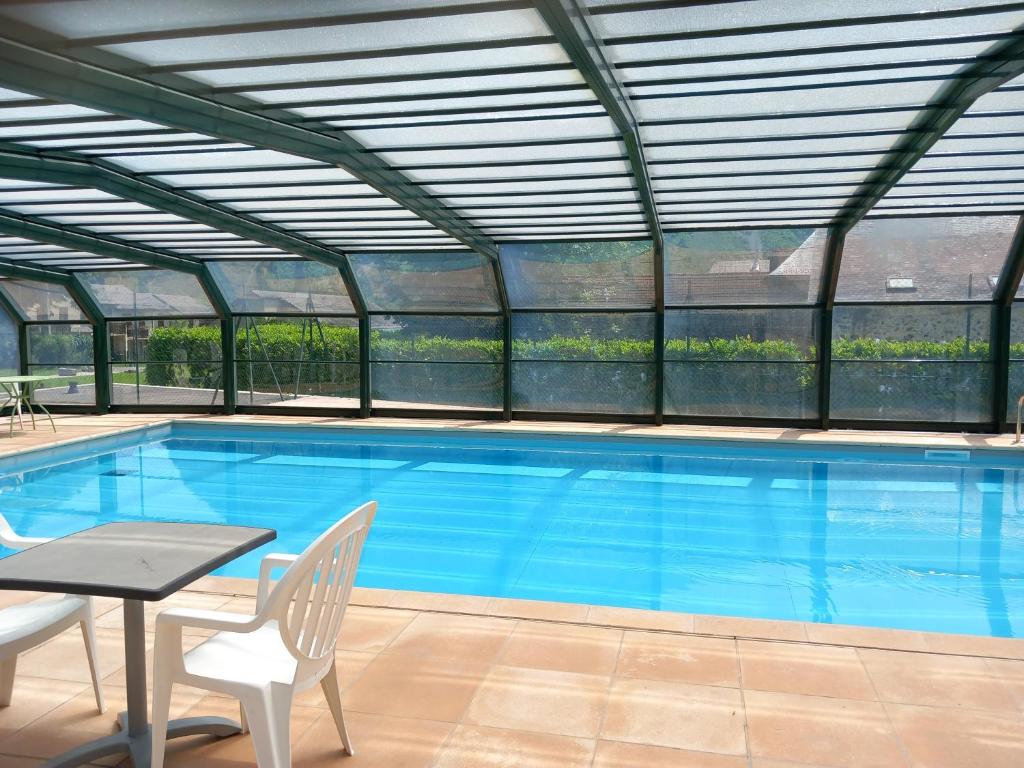a large swimming pool with a retractable roof at Appartement Bielle 106 in Bielle