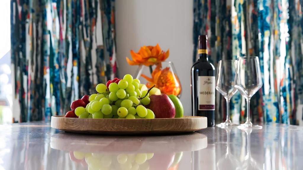 a plate of fruit on a table with a bottle of wine at Apartment by Janzen -E- in Rheine
