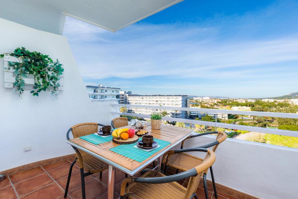a balcony with a wooden table and chairs and a view at Sweet Sea in Port d'Alcudia