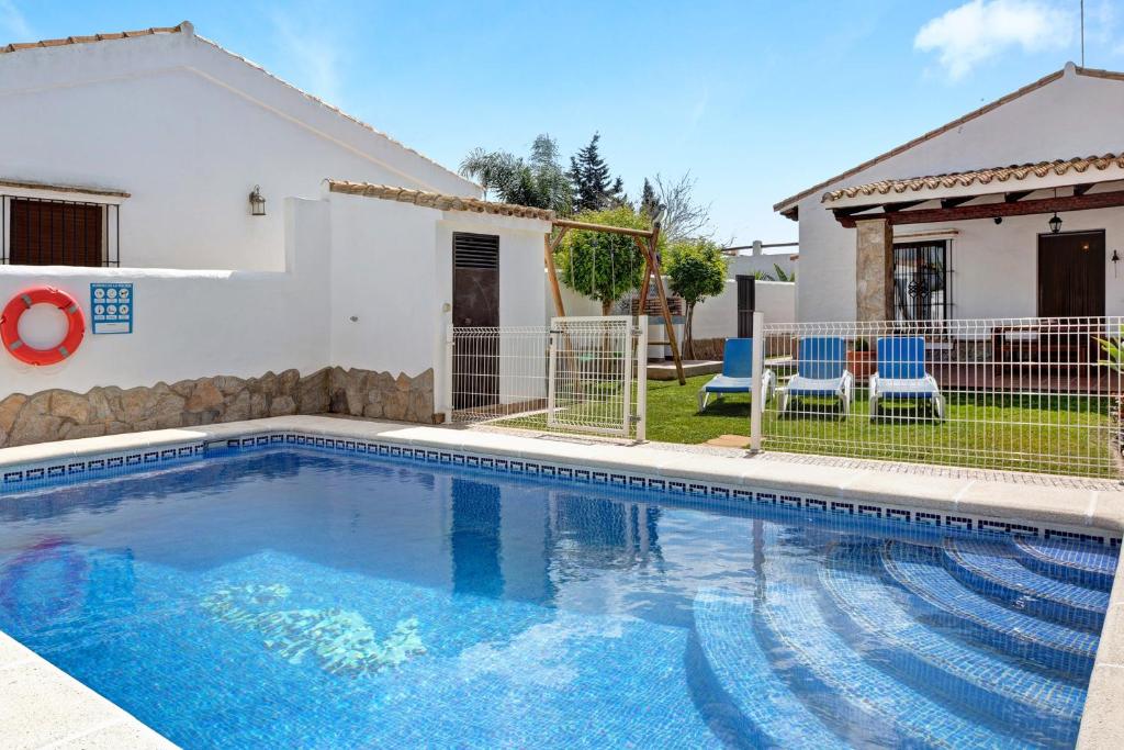 a swimming pool in front of a house at Villa Elsa in Conil de la Frontera