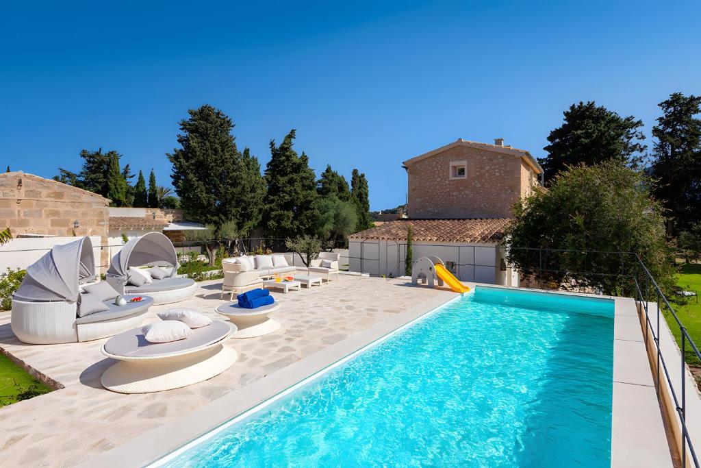 a swimming pool with lounge chairs and a swimming pool at Can Mas Villa Antigua in Pollença
