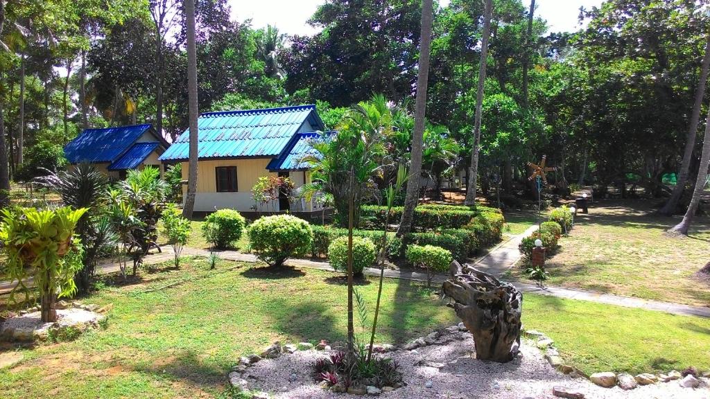 een tuin met een huis op de achtergrond bij Sukorn Andaman Beach Resort in Ko Sukon