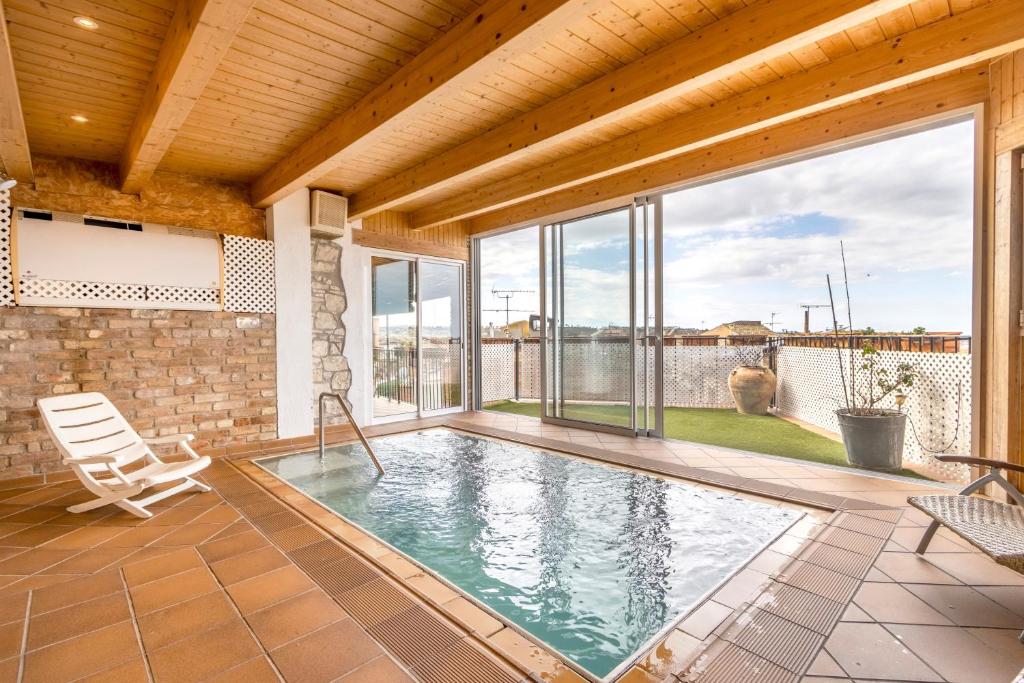 a swimming pool in a house with a patio at Cal Menut in Belianes