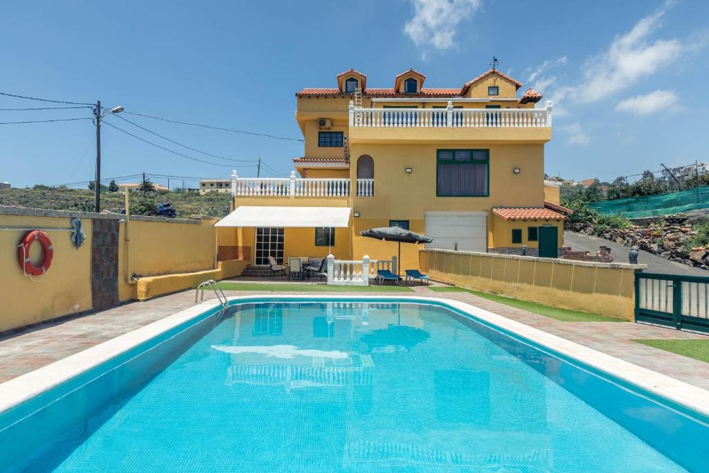 a villa with a swimming pool in front of a house at Apartamento B Armonia Rural in Granadilla de Abona