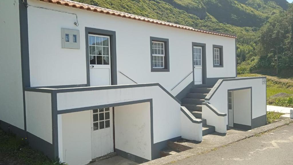 a white building with two doors and stairs at Casa do Avô Almeida in Lajes das Flores