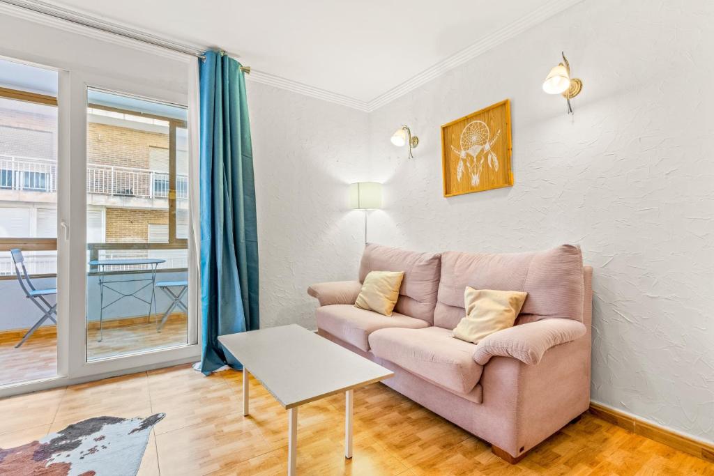 a living room with a pink couch and a table at Unique Apartahotel 3-3 in Torrevieja