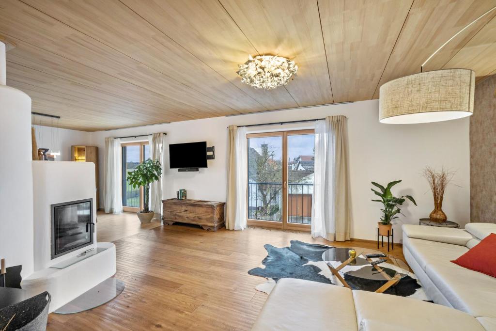 a living room with a couch and a tv at Fewo Mit Herz Und Holz Penzing in Penzing