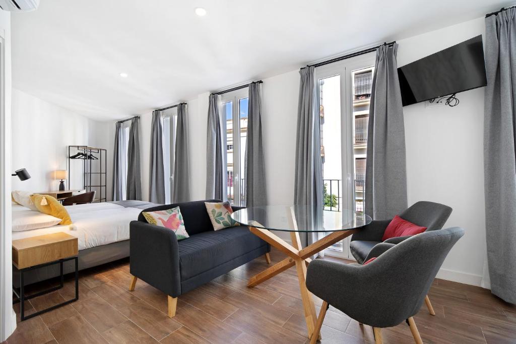 a bedroom with a bed and a glass table and chairs at Casa Milano 1 in Jerez de la Frontera