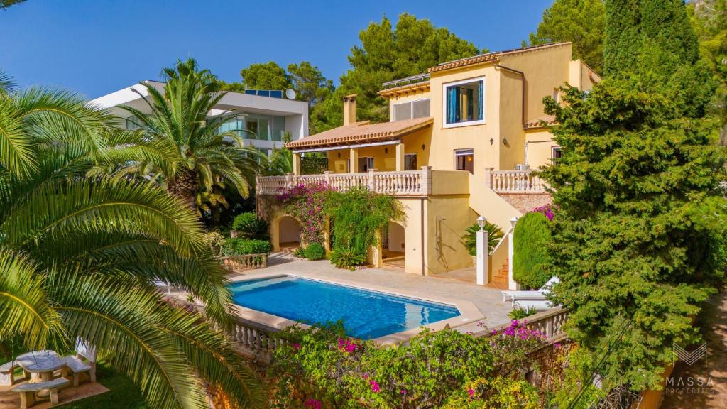 a large house with a swimming pool in front of it at Finca Assindia, Costa de los Pinos in Son Servera