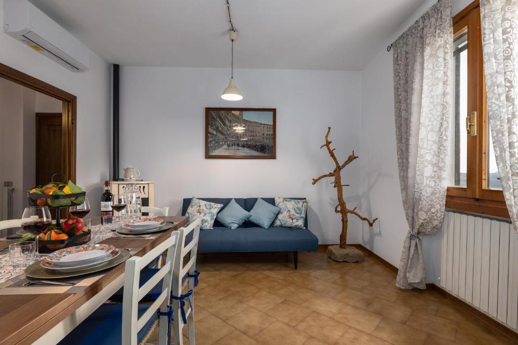 a living room with a table and a blue couch at Podere Sasso 3 in San Gimignano