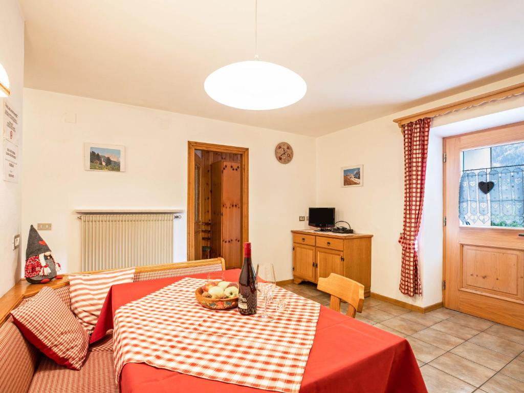 a room with a table with a red and white table cloth at Ciasa Lino Sas da le Undesc in Pozza di Fassa